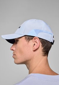 Jasnoniebieska czapka z ciemnobłękitnym daszkiem, o strukturalnym designie i oddychających panelach. Regulowany pasek z tyłu zapewniający dopasowanie.