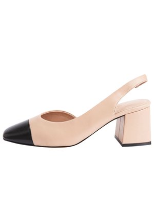 Chaussure slingback en cuir nude à bout pointu et capuchon noir, dotée d'un large talon bloc et d'un côté ouvert. Texture lisse.