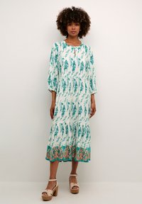 Rochie lungă cu imprimeu floral, cu mâneci trei sferturi, având o fustă în straturi și accente turcoaz la tiv. Material texturat, ușor.