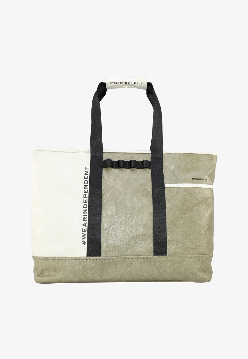 Tote-Bag in Creme und Olivgrün, aus strukturiertem Material gefertigt, mit schwarzen Trägern, einem hängenden Griff und bedrucktem Text an der Seite.