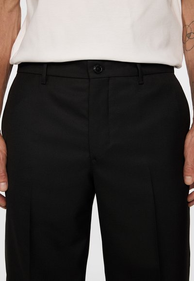 Svarta kostymbyxor med en slät yta, subtil diagonal väv, framfickor och en ensam knappstängning vid midjan.