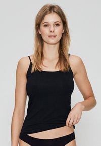 Sort, tætsiddende camisole med tynde stropper og rund halsudskæring. Stoffet virker blødt og glat og tæt omfavner kroppen.