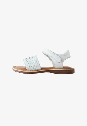 Hvid flad sandal med flettet frontrem, ankelrem med velcrolukning og brun sål.