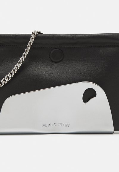 Black leather clutch bag featuring a chrome accent with a rounded cutout. Includes a silver chain strap and embossed text reading "PUBLISHED BY."