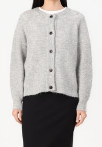 Světle šedý pletený cardigan s kulatým výstřihem, ribovanou strukturou a tmavými knoflíky, s krátkým lemem a dlouhými rukávy.