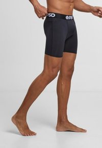 Boxer-briefs noirs avec une ceinture confortable arborant le logo "PSD", en tissu lisse, longueur mi-cuisse et un design ajusté.