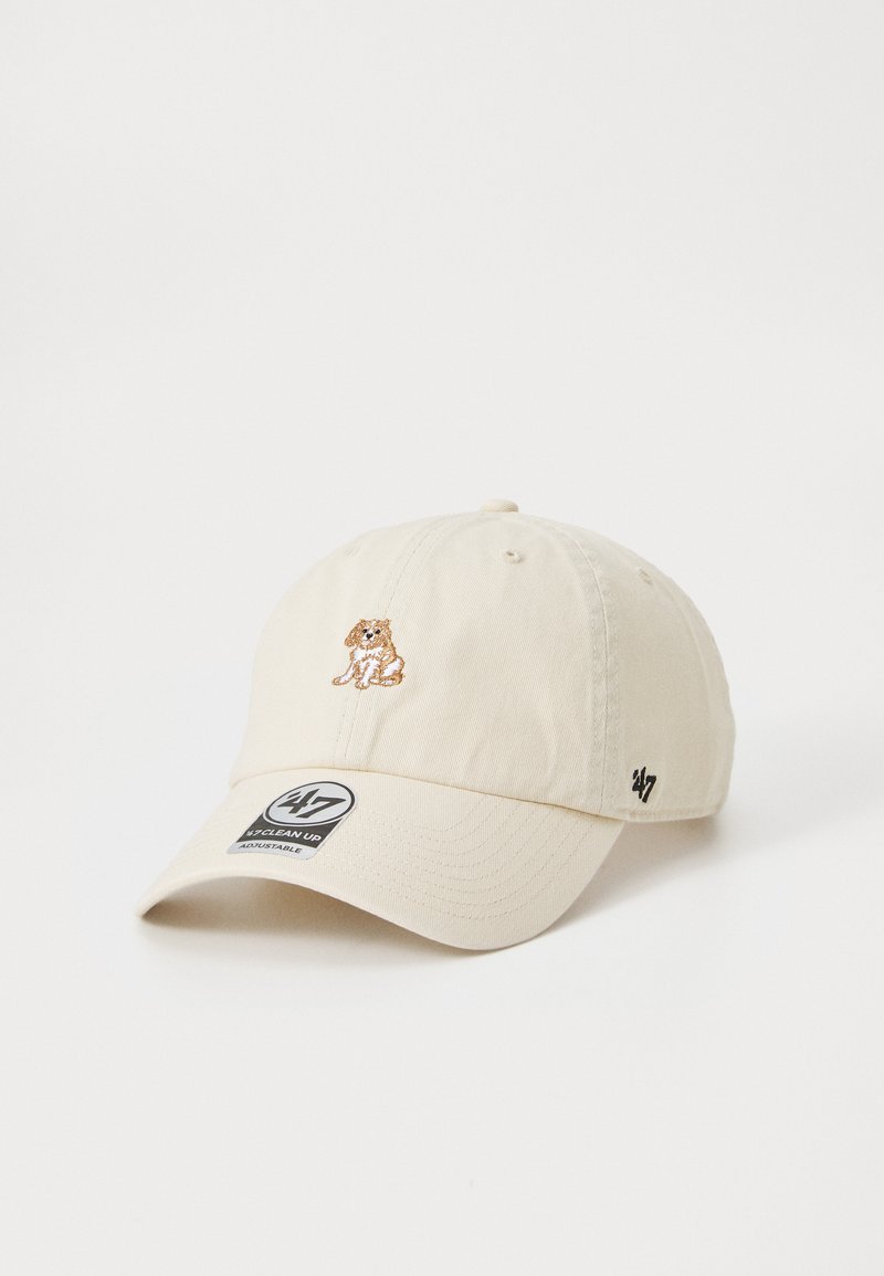 Beige cap made of cotton with an adjustable strap. Features an embroidered dog design on the front and a logo patch on the side.