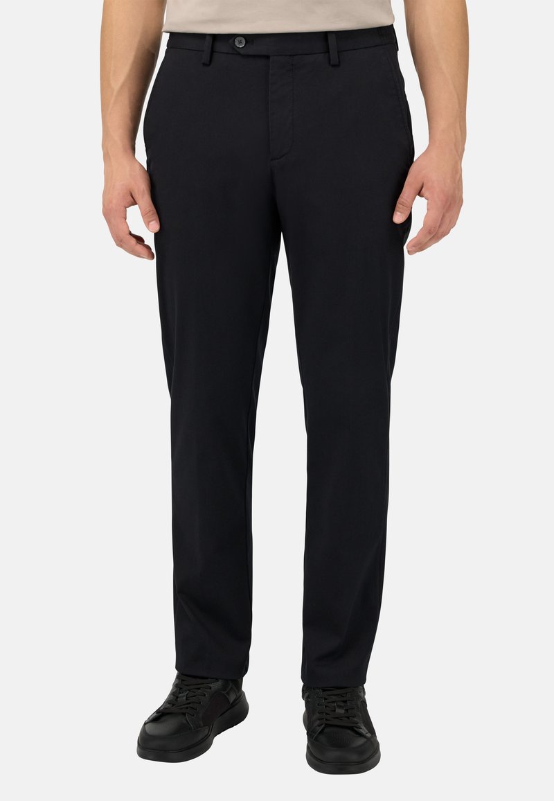 Melni bikses, kas izgatavotas no kokvilnas un sintētisko šķiedru maisījuma, ar plakanu priekšpusi, standarta kabatām un klasisku piegriezumu, apvienotas ar melniem sporta apaviem.