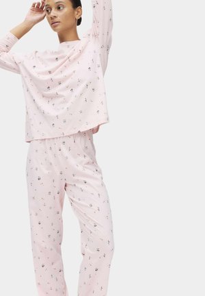 Ensemble de pyjama rose comprenant un haut à manches longues à coupe décontractée et un pantalon assorti, tous deux ornés de motifs multicolores ludiques. Tissu au toucher doux.