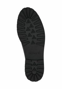 Suola in gomma nera con scanalature profonde per una maggiore aderenza. Presenta motivi in rilievo e il marchio "Caprice" sul tallone.