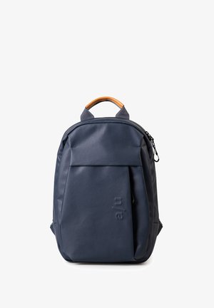 Dunkelblauer Rucksack mit glatter Textur, braunem Leder-Tragegriff, Fronttasche und einem dezenten geprägten Logo an der Seite.