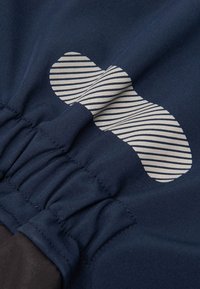 Navy blue fabric with gathered detail, featuring a large cream-colored striped pattern element. Smooth texture and seamless stitching.