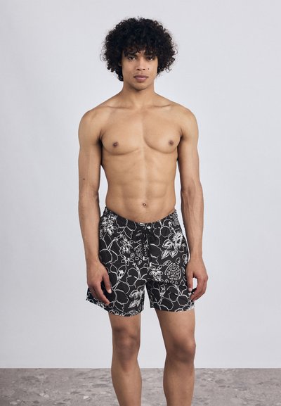 Čierne plavky s bielymi kvetinovými vzormi, elastický pás a šnúrka na stiahnutie. Mäkká tkanina, strih po kolená, vhodné na pláž.