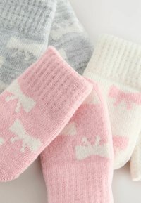 Chaussettes colorées en gris, rose et blanc. Chacune présente un bord côtelé et un motif de nœuds, fabriquées à partir d'un matériau doux et texturé.