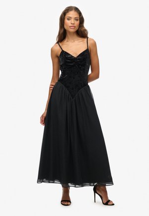 Robe noire avec un corsage en velours ajusté, décolleté en cœur et bretelles réglables, se déversant dans une jupe en chiffon plissée et douce.