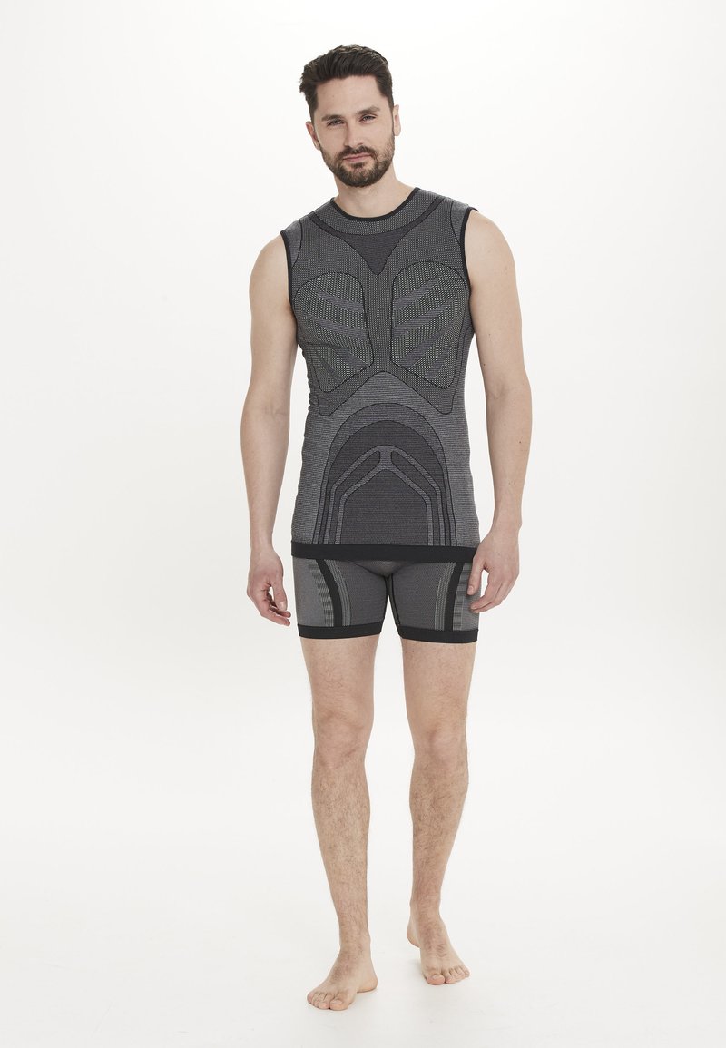 Grå ärmlös atletisk topp med texturerade mönster och matchande åtsittande shorts, båda med elastiska band och kontrasterande mörka accenter.