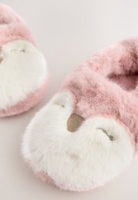 Chaussons roses duveteux avec motif de visage de renard. Matière en fausse fourrure douce, accents blancs pour les yeux et le museau, détail de nez texturé en beige.