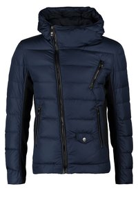 Marinblå pufferjacka med hög krage, dragkedja fram och svarta detaljer. Har vadderad textur och flera dragkedjeförsedda fickor.