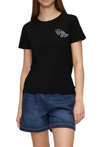 Zwarte katoen t-shirt met een tekstgrafiek die "LAAT DE ZON IN JE HART" leest op de bovenste linkerborst.