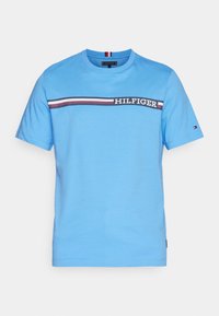 Blå bomullströja med korta ärmar, med ett horisontellt randigt mönster i marinblått, rött och vitt, och "HILFIGER" broderat över framsidan.