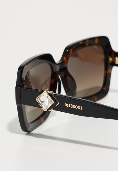 Juodos tortoiseshell akinių rėmas su rudais gradientiniais objektyvais, su deimanto formos kristaliniu akcentu juodame šone, pažymėtas "MISSONI."