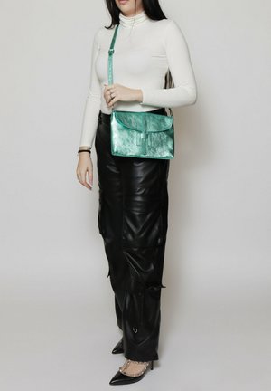 Borsa a tracolla metallica color teal con chiusura a patta e tracolla regolabile, caratterizzata da una superficie liscia e forma rettangolare.
