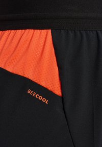 Svart och orange idrottstyg med nätstruktur och "BEECOOL"-logotyp tryckt i orange.