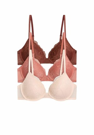 Trois soutiens-gorge en dentelle crème, rose poudré et marron, disposés en pile avec des bretelles réglables.