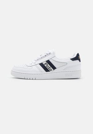 White low-top sneaker with navy blue stripes and "Polo" text on the side, perforated toe, and a thick rubber sole.
