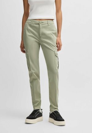 Light green cargo pants made of cotton blend, feature side pockets, slim fit, and a flat front with button closure. Paired with black sneakers.