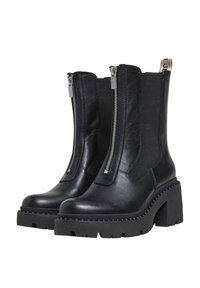 Botines de cuero negro con suela gruesa, cremalleras laterales, inserciones elásticas y un tacón pronunciado. Acabado texturizado con detalle de costura.