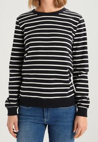 Černobílý pruhovaný svetr s kulatým výstřihem, dlouhými rukávy, žebrovaným lemem a manžetami. Vyrobený z měkkého materiálu, navržený pro pohodlí.