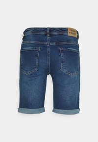 Jeans šorts v temno modri barvi z gladko teksturo, ki imajo zavihane robove, dva zadnja žepa in blagovno znamko iz usnja na pasu.