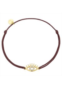 Zlati amulet v obliki očesa s prozornim kamnom v središču, nameščen na pletenem burgundskem vrvici z vozlom in okroglo zlatno oznako.