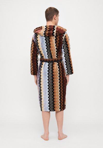 Halat de baie cu glugă, decorat cu un model zigzag în nuanțe de marron, bej, negru și albastru deschis. Fabricat din material plușat, până la jumătatea gambei.