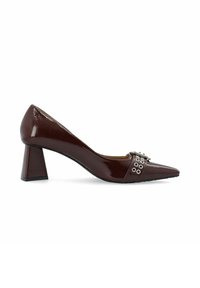 Décolleté in vernice bordeaux con tacco alto, punta affilata e tacco spesso. Presenta dettagli in metallo argentato con ritagli circolari.