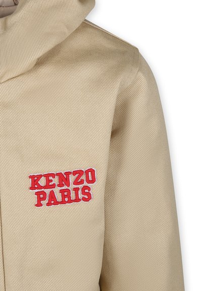 Veste brune avec un tissu texturé, une capuche et un logo brodé en rouge "KENZO PARIS" sur la zone gauche de la poitrine.