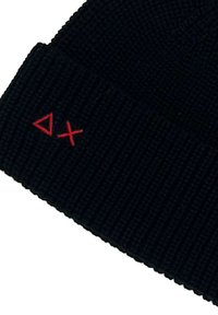 Berretto a coste nero con piccoli simboli triangolari rossi e croci ricamati vicino al bordo.