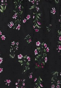 Tessuto nero con un motivo floreale che presenta fiori rosa e verdi, inclusi piccoli boccioli e foglie, su uno sfondo texture.