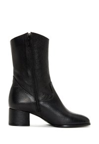 Bota de tobillo de cuero negro con una superficie texturizada, cierre de cremallera lateral, puntera semiredondeada y un tacón bajo de bloque.