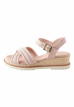 Jasnoróżowa sandałka na koturnie z wyściełanymi, skrzyżowanymi paskami, paskiem wokół kostki ze złotą klamrą i plecioną, teksturowaną platformą.