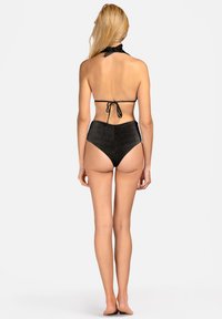 Czarny bikini z halką na szyi i wysokim stanem. Teksturyzowany materiał, związany pasek na szyi i minimalne zakrycie z tyłu.