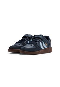 Marineblaue Sneaker aus Leder und Wildleder. Mit hellblauen Streifen, perforierter Zehenpartie und brauner Gummisohle. Verstellbarer Riemen.