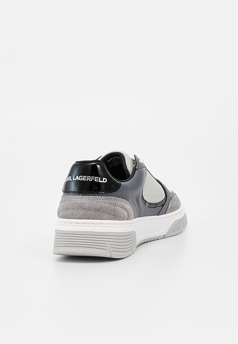 Zapatilla Karl Lagerfeld negra y gris con detalles en ante, suela blanca y logo en el talón, mostrada desde una vista trasera de tres cuartos.