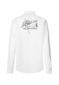 Camisa blanca de manga larga con cuello abotonado, gráfica detallada en la parte posterior con texto y una palmera, fabricada con tejido liviano.