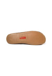 Sole in gomma marrone con grip testurizzato, caratterizzata da una parte superiore beige con un logo brandizzato in rosso. Design piatto e materiale morbido per il comfort.