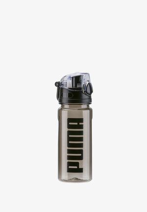 Botella de agua de plástico transparente con una tapa negra, que presenta un cuerpo transparente, un gran logo negro de "PUMA" y una tapa abatible para un fácil acceso.