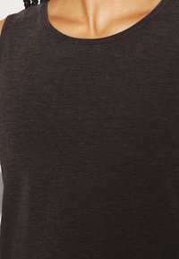 Canotta senza maniche grigio scuro con un tessuto morbido e texture, ideale per un look casual o per essere usata come strato.