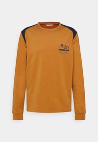 Sweat-shirt à manches longues couleur moutarde avec des panneaux d'épaule noirs, un petit graphique de vélo et le texte "how" sur le côté gauche de la poitrine.