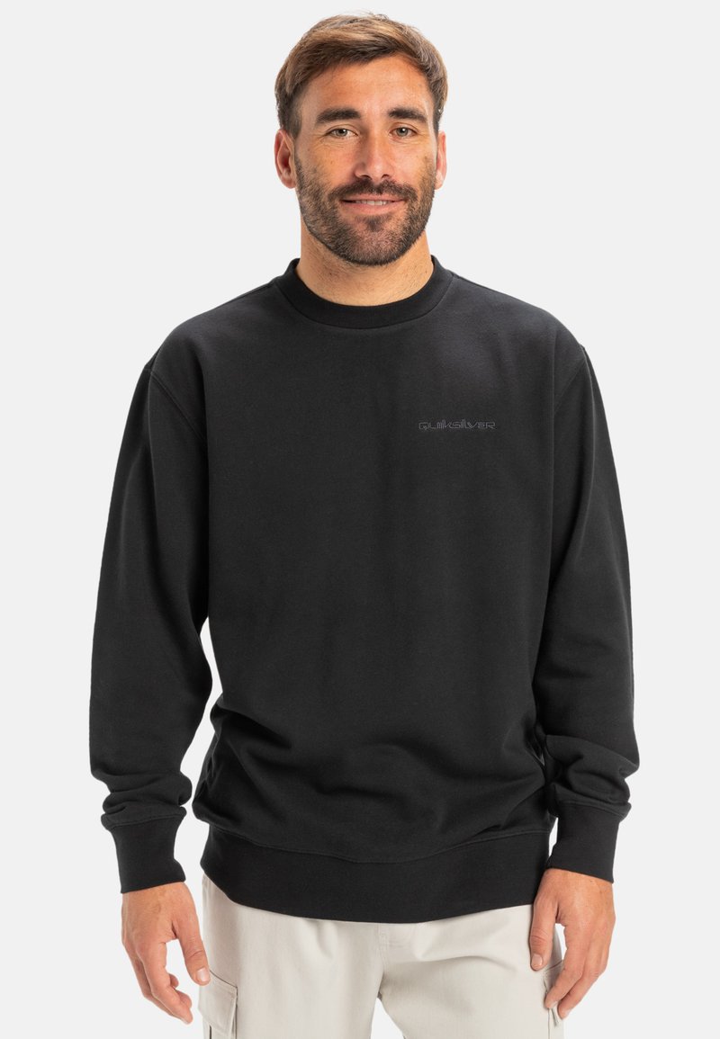 Sudadera de algodón negra con cuello redondo y mangas largas. Presenta un logo sutil en el pecho. Está hecha de una tela suave y texturizada.